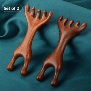 Set of 2 natural sandalwood 5-claw scalp massagers on elegant green silk background