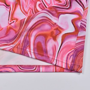 Gros plan d'une robe imprimé marbre rose montrant les détails de l'ourlet à double couture