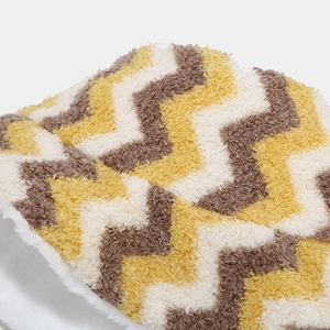 Detail of double-sided bucket hat with warm plush texture and yellow chevron pattern