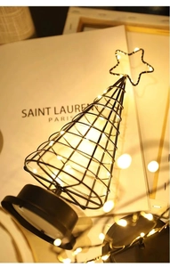 Gros plan d'un sapin de Noël en fer noir minimaliste avec des lumières LED blanc chaud