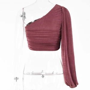 Détail du haut bordeaux à une épaule et manches longues avec texture plissée chic