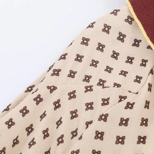 Close-up of geometric print fabric and burgundy collar stitching on long dress