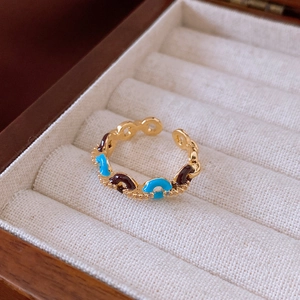Macro shot of gold-plated chain ring with blue enamel and fine crystal accents