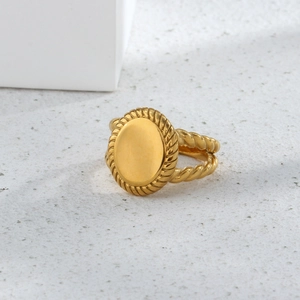 Detail of 18K gold-plated oval signet ring with twisted rope texture band on a clean surface