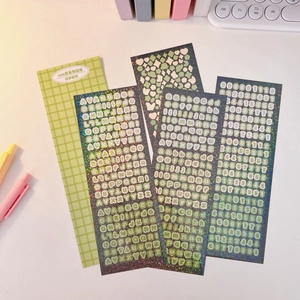 Detail of glitter laser stickers with green letters and numbers for scrapbooking