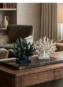 Macro shot of faux coral sculptures in white and green on modern square pedestals