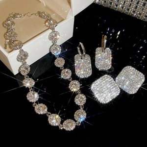 Vista dettagliata della collana argento e orecchini di strass su superficie riflettente