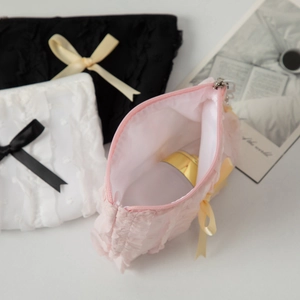 Chic lace cosmetic bags with bows in black, white, and pink showing spacious interior