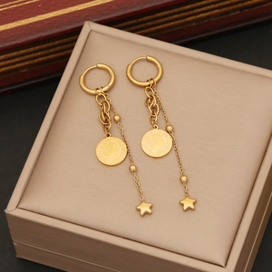 Golden coin and star pendant earrings with chain details displayed in a jewelry box