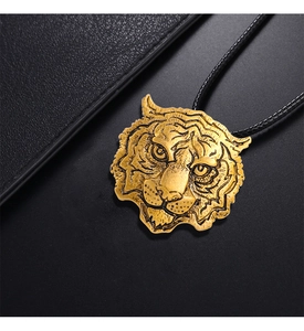 Detailed macro view of the golden tiger head pendant with black woven rope necklace