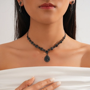 Gothic style necklace and earrings set with black teardrop crystals on model