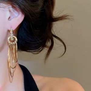 Orecchini a cerchio multistrato in oro con cristalli indossati da una modella elegante