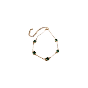 Gold plated bracelet with emerald green square zircon stones in a luxury minimalist style