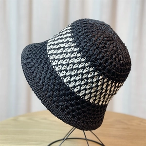 Detailed view of the tight woven texture and black-white stripe pattern on the straw sun hat