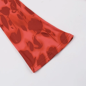 Detailed close-up of the red rose floral print and fine stitching on the dress sleeve cuff