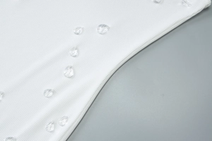 Dettaglio di maglia a coste bianca con decorazioni in strass di cristallo a goccia