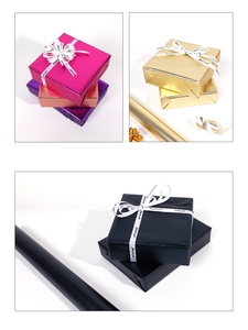 Detail of metallic matte gift wrapping paper rolls in rose red, purple, gold and black colors