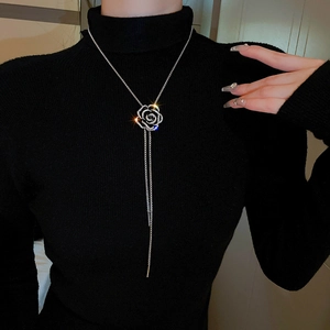 Detailed view of silver rose necklace with rhinestone pendant and long tassels on model
