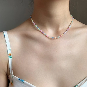 Close-up of a colorful beaded collar necklace with cat-eye stones on a model's neck