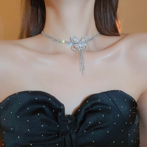 Close-up of a silver butterfly necklace with zircon tassels worn by a model