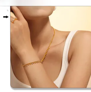 Close-up of gold beaded fringe necklace and matching rhinestone bracelet on a model
