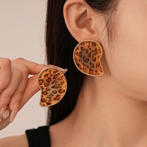 Close-up of leopard print resin earrings with golden metal borders on female model