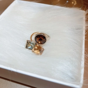 Macro shot of silver ring featuring multi-color geometric zircon stones in a gift box