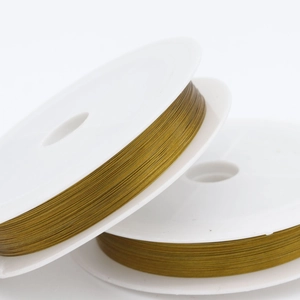 Macro detail of fine golden beading wire wrapped on white plastic spools for DIY jewelry