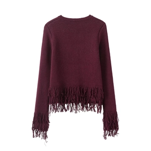 Detail of burgundy knit cardigan featuring fringe trim on cuffs and hemline
