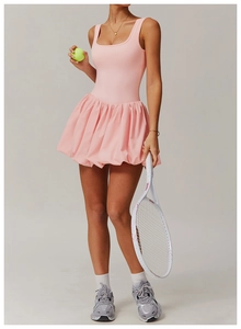 Detailed view of a pink tennis dress featuring a pleated bubble skirt and U-shaped neckline