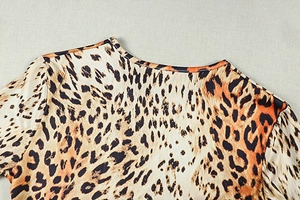 Detailed close-up of the round neckline and leopard print pattern on elastic fabric