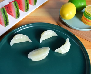 Macro detail of miniature dumpling models with realistic texture on a green tray
