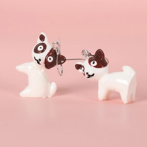Cute cartoon bulldog earrings with lace ribbon tassels on a soft pink background