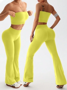 Macro view of seamless high-waisted flared yoga pants and neon yellow ribbed tank top set