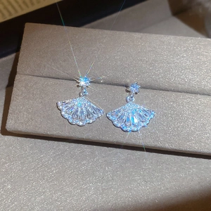 Detailed macro view of fan-shaped silver earrings with sparkling cubic zirconia inlay