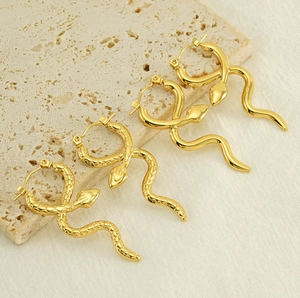 Detailed view of snake-shaped gold hoop earrings with smooth and scaled textures