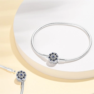 Detailed macro shot of S925 silver snake chain bracelet with blue stone helm charm