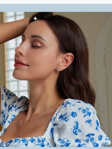 Model wearing sterling silver Celtic knot stud earrings with polished white gold finish