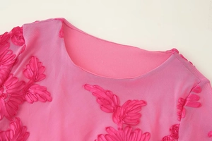 Detail von rosa Netz-Kleid mit 3D-Satinband-Blumenstickerei und einem Rundhalsausschnitt