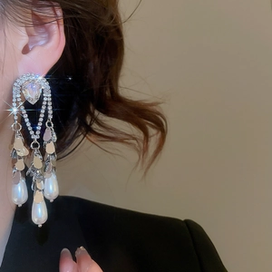 Detail of elegant silver tassel earrings with crystal rhinestones and teardrop pearls