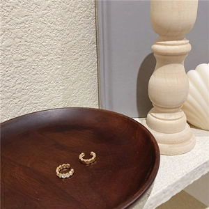Détail de l'ensemble de bagues d'oreille dorées avec strass sur un plateau en bois