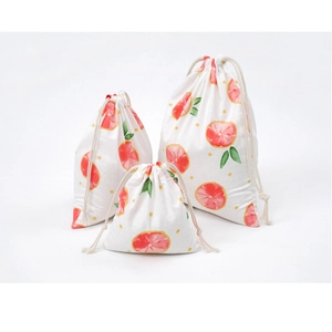 Detailed set of three linen drawstring bags featuring fresh grapefruit and polka dot patterns