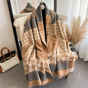Classic camel and grey houndstooth thick shawl scarf with tassels on a beige chair