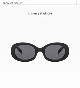 Detailed view of glossy black oval sunglasses with dark gray lenses and triple stud accents