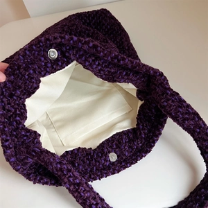 Dettaglio interno della borsa in tweed viola con fibbia magnetica e fodera in tela