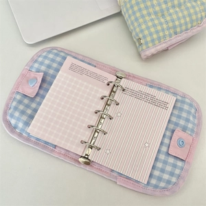 Detail of pink quilted binder notebook with silver six-hole metal rings and heart clasp