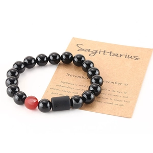 Detailed macro view of Sagittarius charm bracelet with black beads and red accent bead