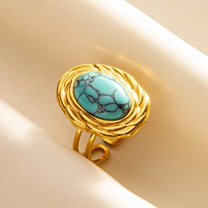 Macro view of adjustable gold ring with oval turquoise stone and woven bezel detail