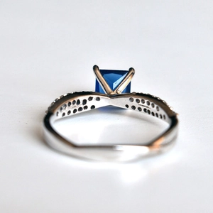 Λήψη macro: Δαχτυλίδι με μπλε ζαφείρι princess cut και χιαστί μπάντα με διαμάντια