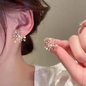 Gros plan détaillé de boucles d'oreilles étoiles dorées avec perles et zircons